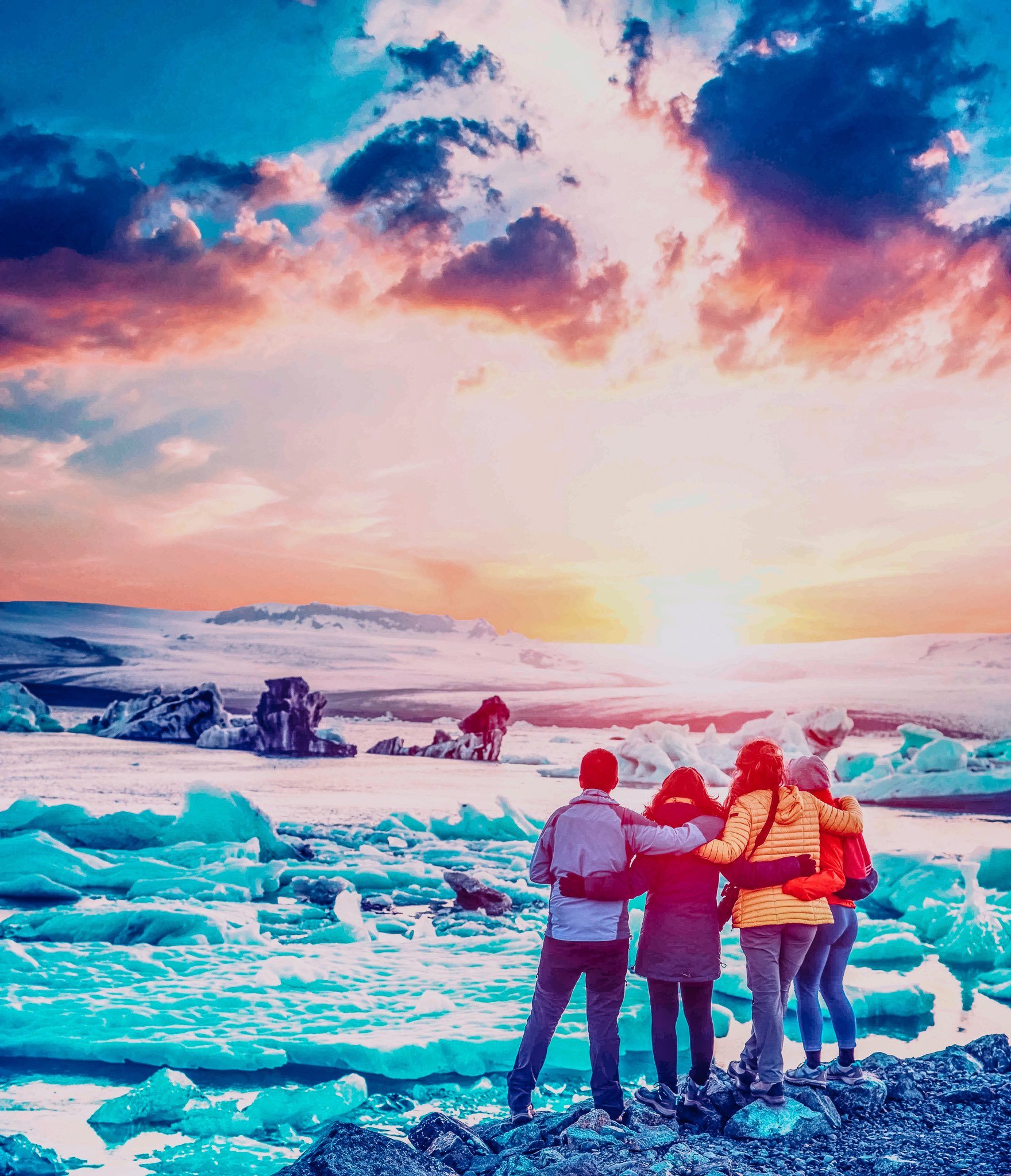 Four friends are looking at the sunset in the famous Jokulsarlon ice lagoon in Iceland. Exotic countries. Amazing places. (memories, impressions, rest, relaxation - concept)